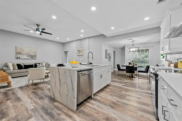 a very nice looking living room with stainless steel appliances granite countertop furniture and a wooden floor