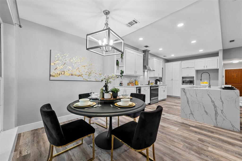 303 Riva Ridge Wylie, TX 75098 - Photo 15 of 38 a dining room with wooden floor a chandelier a wooden table and chairs
