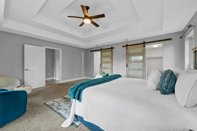 a bedroom with a large bed and a chandelier