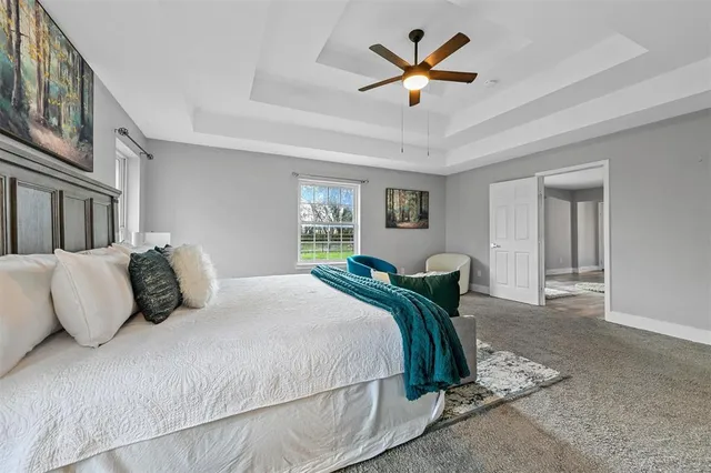 a bedroom with a large bed and a chandelier