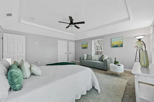 a bedroom with a bed mirror and couch