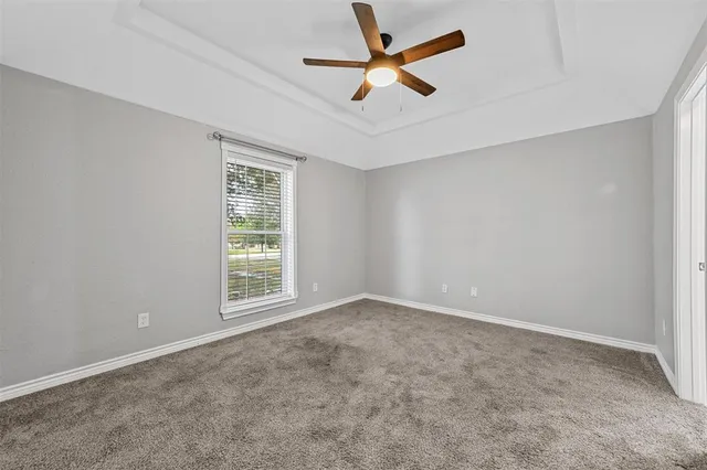 an empty room with a window and a fan