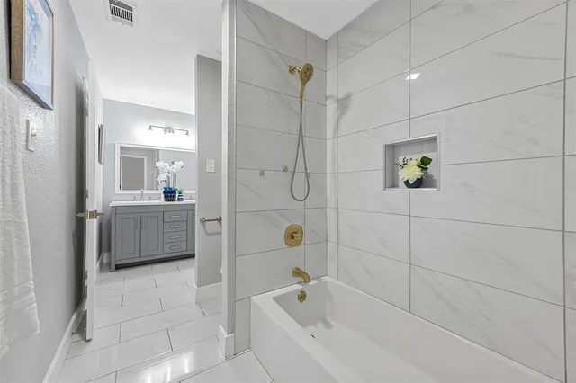 a bathroom with a bathtub a shower a sink and mirror