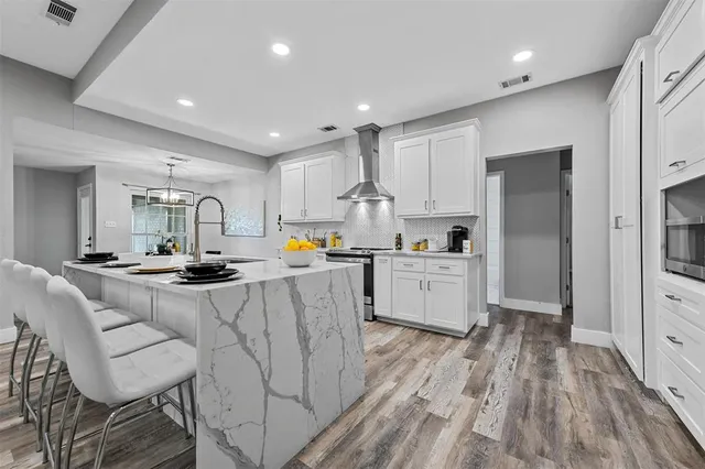 a kitchen with white cabinets and stainless steel appliances