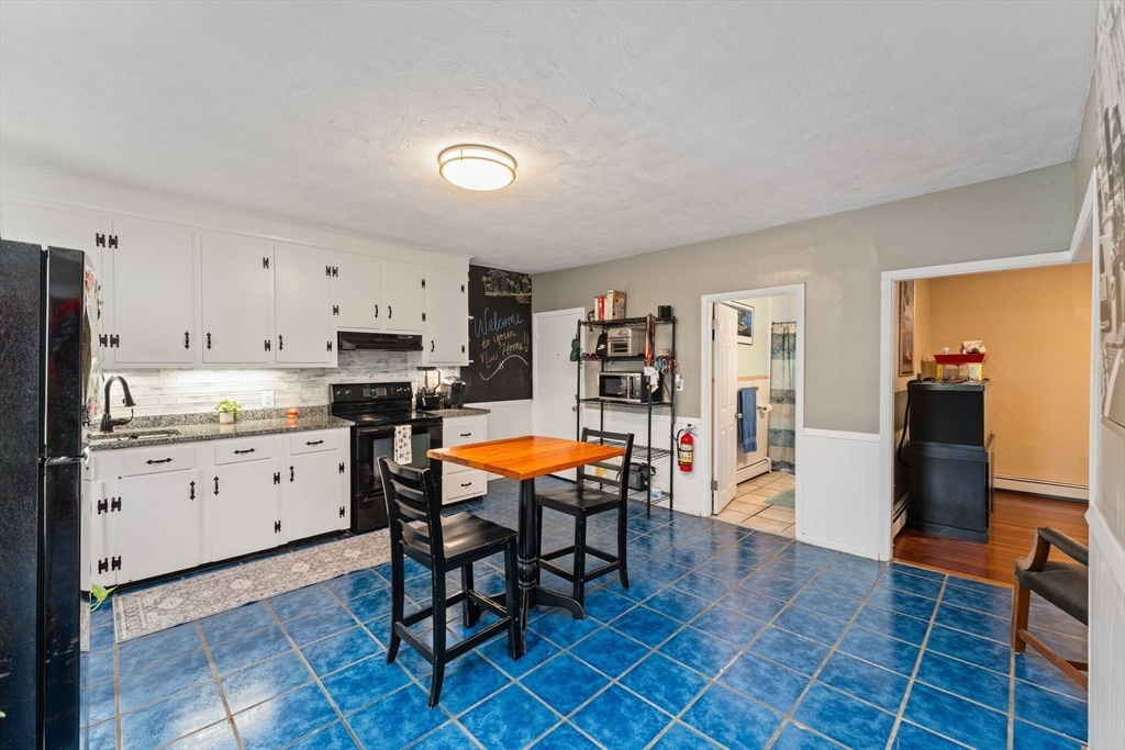 185 West Avenue Pawtucket, RI 02860 - Photo 17 of 40 a large white kitchen with stainless steel appliances granite countertop a stove a sink a dining table and chair
