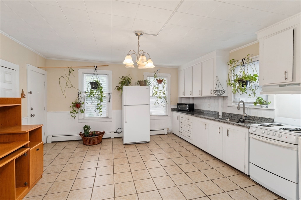 185 West Avenue Pawtucket, RI 02860 - Photo 5 of 40 a kitchen with a refrigerator a stove a sink cabinets and a window