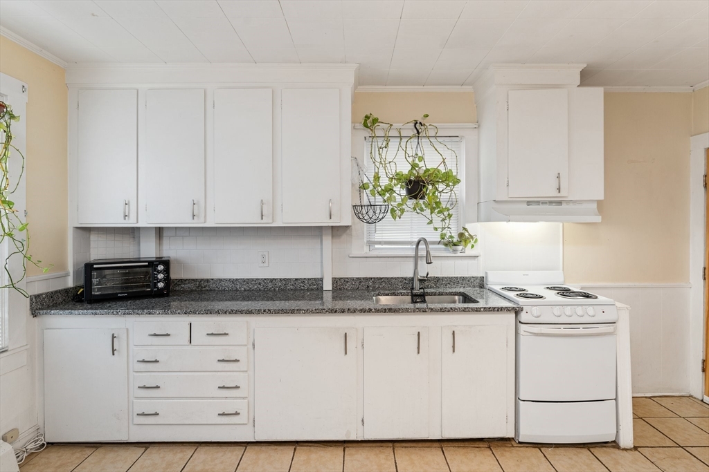 185 West Avenue Pawtucket, RI 02860 - Photo 6 of 40 a kitchen with granite countertop white cabinets and white appliances