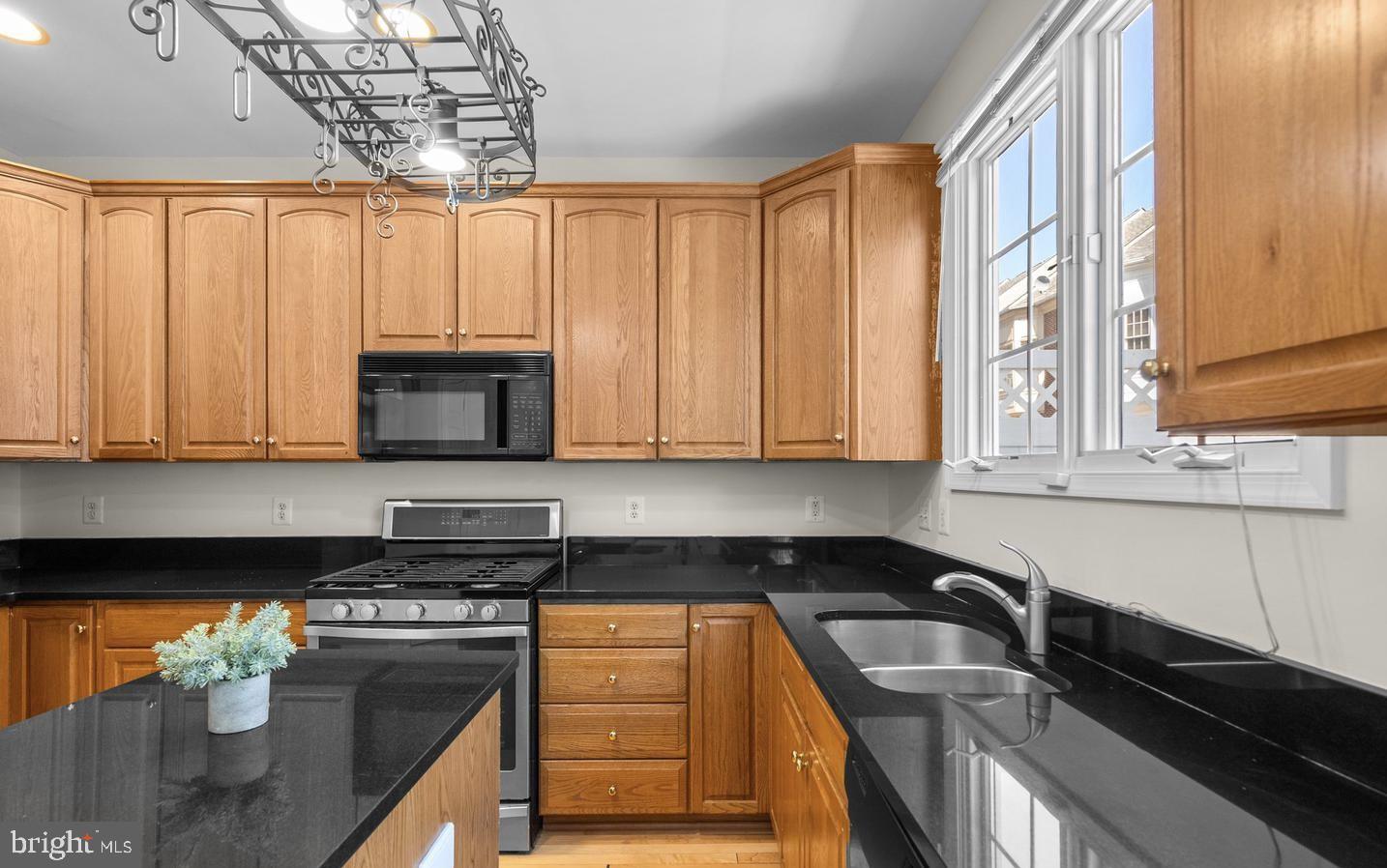 8509 2nd Avenue Silver Spring, MD 20910 - Photo 3 of 16 a kitchen with stainless steel appliances granite countertop a sink a stove and a microwave