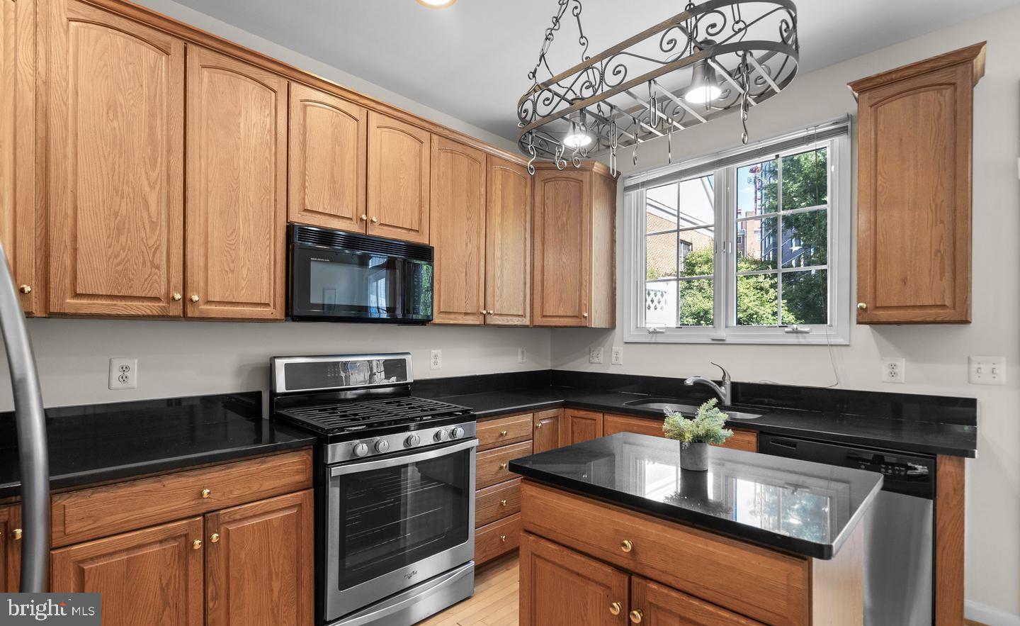 8509 2nd Avenue Silver Spring, MD 20910 - Photo 5 of 16 a kitchen with stainless steel appliances granite countertop a sink a stove and a microwave