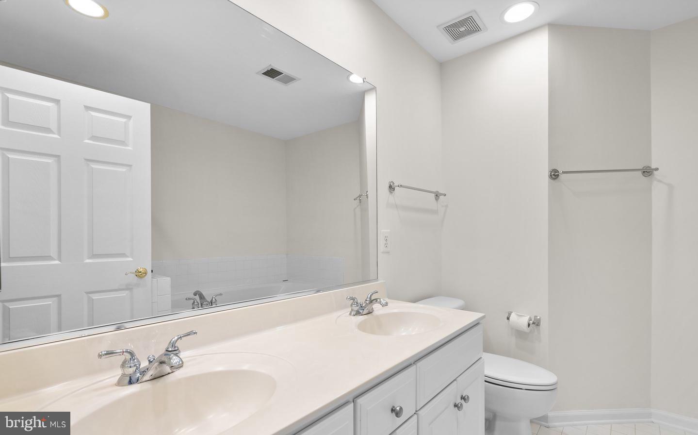 8509 2nd Avenue Silver Spring, MD 20910 - Photo 9 of 16 a bathroom with a granite countertop sink a toilet and a mirror