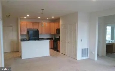 a view of kitchen with stainless steel appliances kitchen island refrigerator stove and microwave