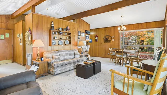 a living room with furniture a flat screen tv and a floor to ceiling window