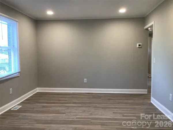 a view of room with window and wooden floor