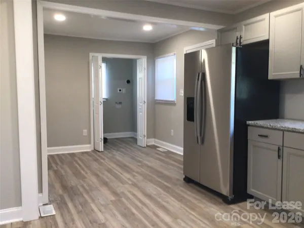a view of a refrigerator in kitchen and a wooden floor