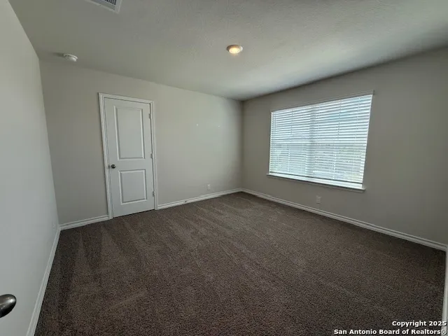 a view of a hallway with a livingroom and a bathroom