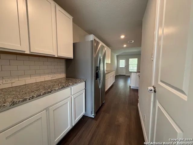 a kitchen with granite countertop a sink and a stove top oven