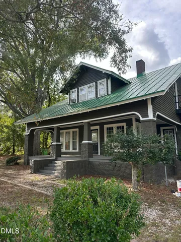 a front view of a house with yard and green space