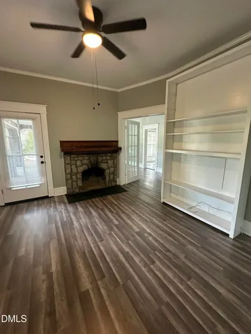 a room with wooden floor a ceiling fan and a window