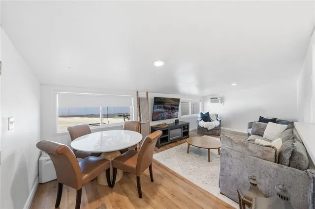 a living room with furniture a flat screen tv and kitchen view
