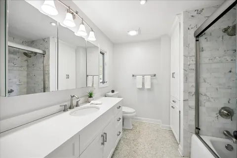 a bathroom with a tub sink double vanity and a mirror