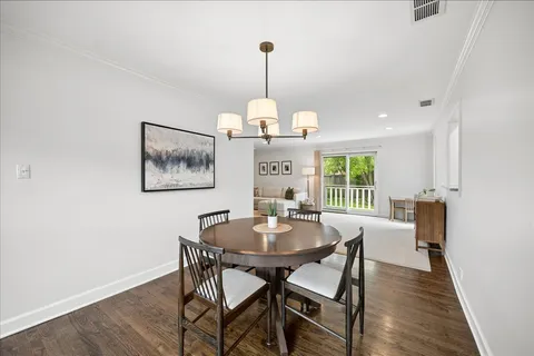 a dining room with furniture a chandelier and wooden floor