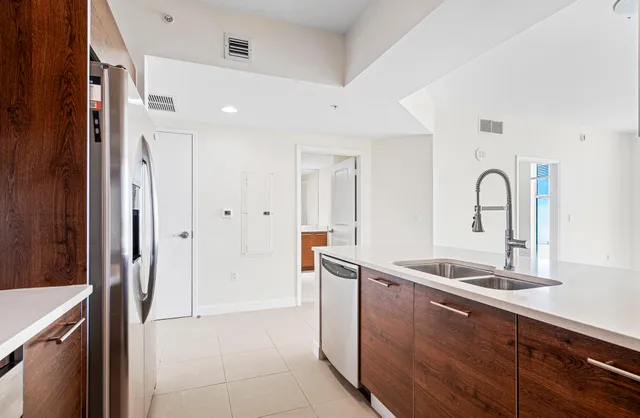a kitchen with stainless steel appliances granite countertop a sink and a refrigerator