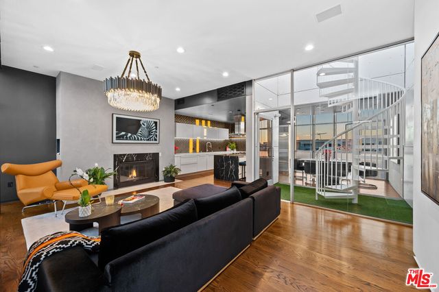 a living room with furniture a fireplace and a floor to ceiling window