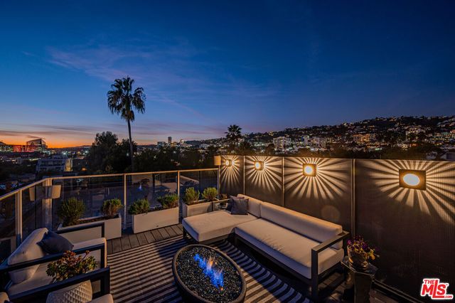 a view of a roof deck with couches and wooden floor