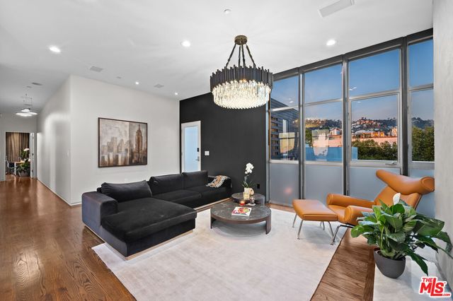 a living room with furniture potted plant and a chandelier