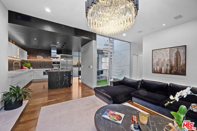 a living room with furniture wooden floor and a chandelier