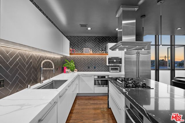 a kitchen with stainless steel appliances granite countertop a sink and stove
