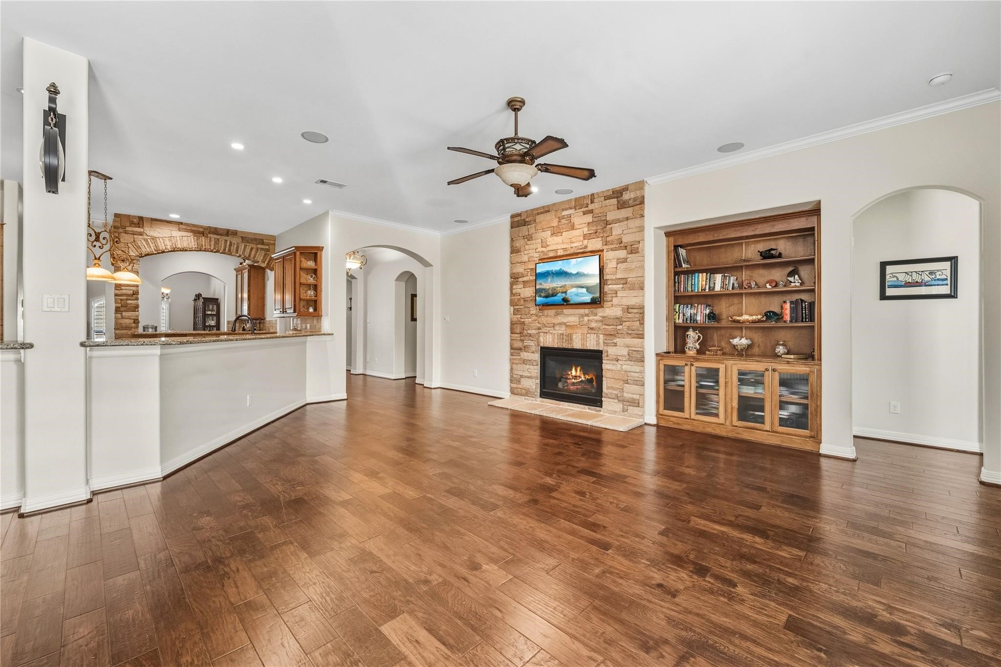 137 Silverwood Ranch Drive Shenandoah, TX 77384 - Photo 9 of 37 Open Living area features stone-rock Fireplace with gas logs.