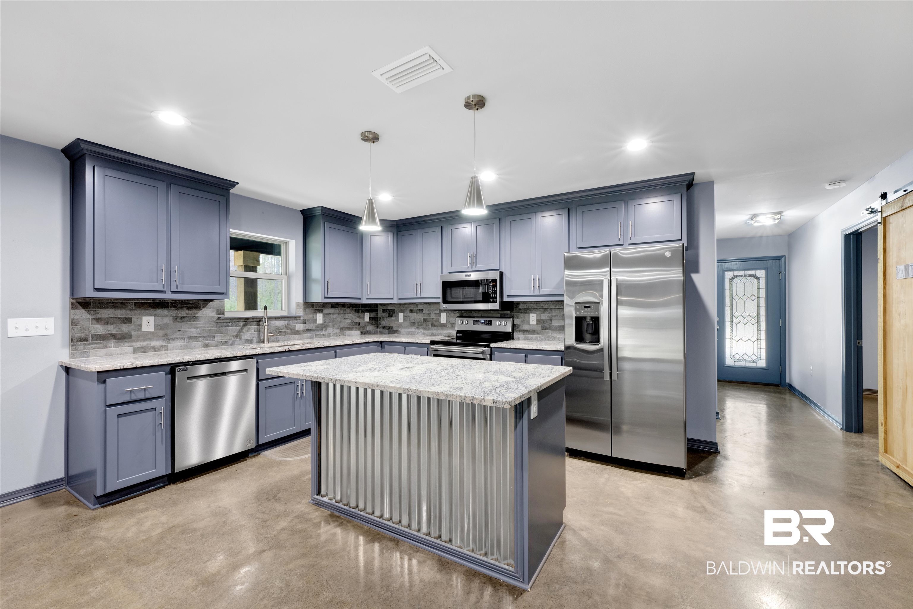 36397 Alexandria Trail Stapleton, AL 36578 - Photo 29 of 65 Kitchen featuring a barn door, stainless steel appliances, concrete floors, light stone counters, and a center island