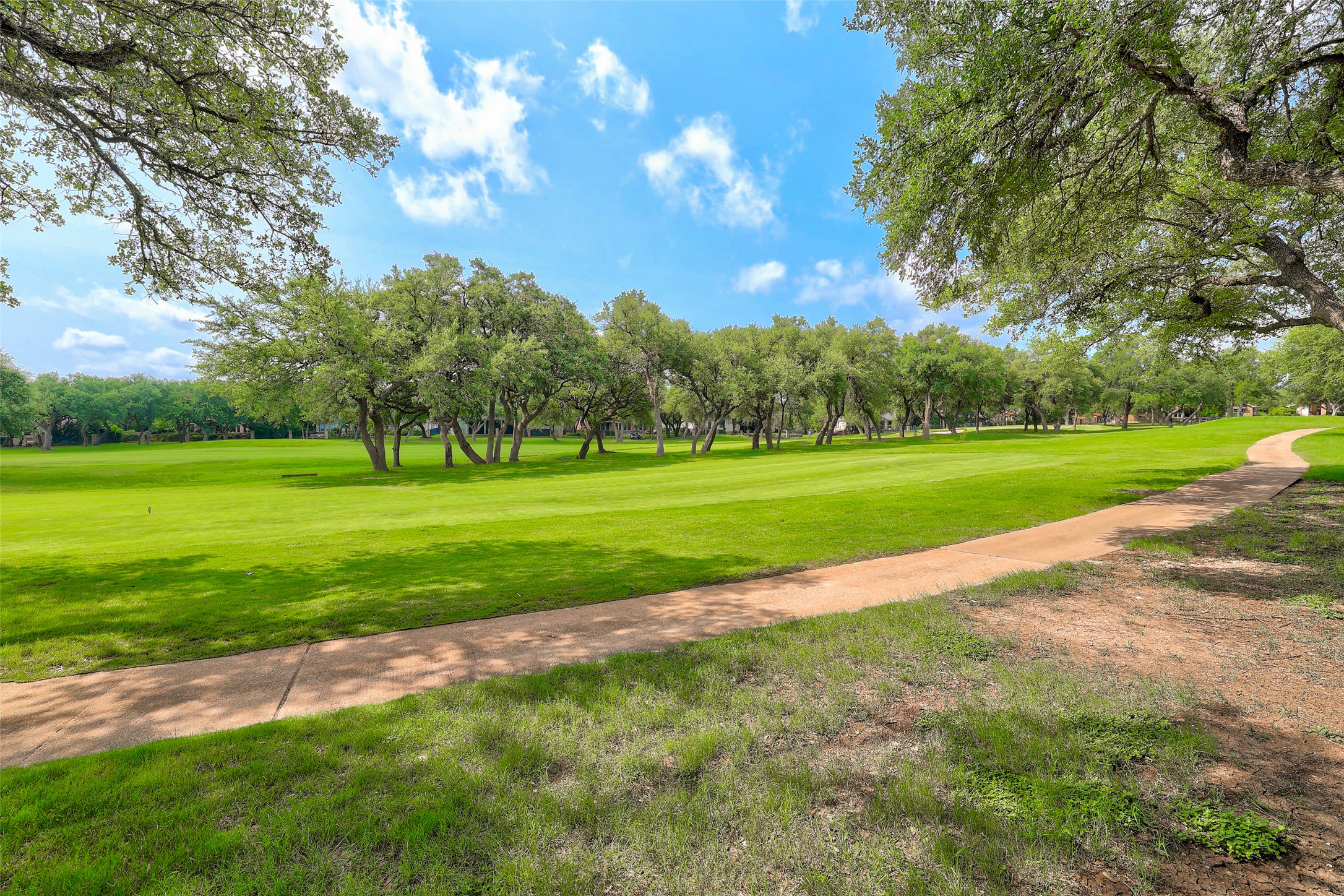 33 Meadows End Georgetown, TX 78628 - Photo 40 of 40 A winding pathway guides through a verdant golf course, shaded by mature trees.