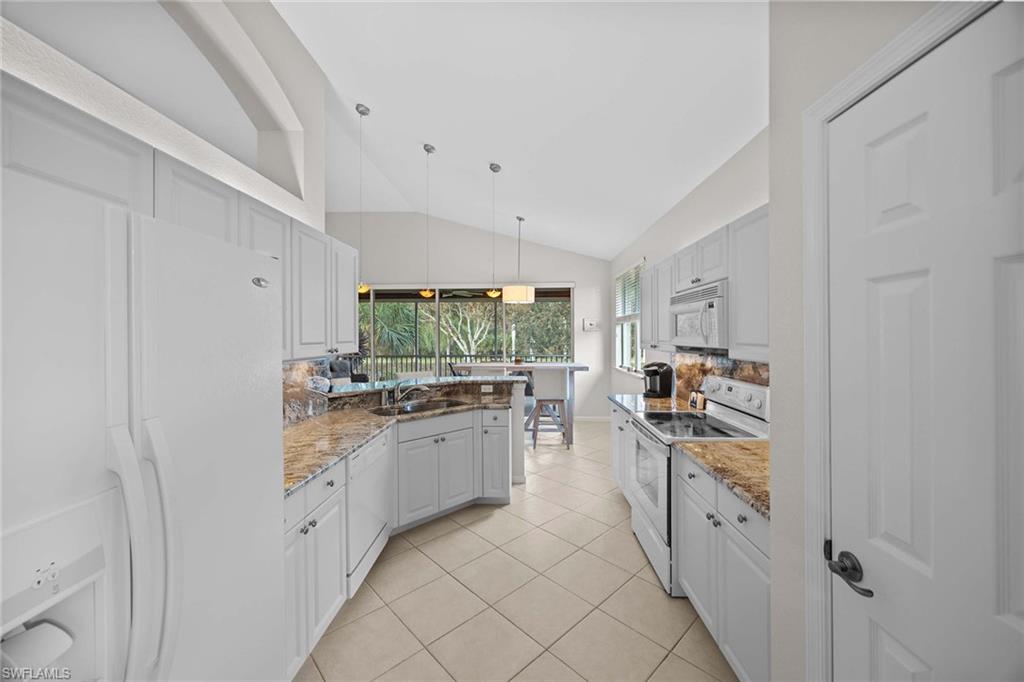 6864 Ascot Drive, Unit 5202 Naples, FL 34113 - Photo 13 of 36 a kitchen with stainless steel appliances a sink and a refrigerator
