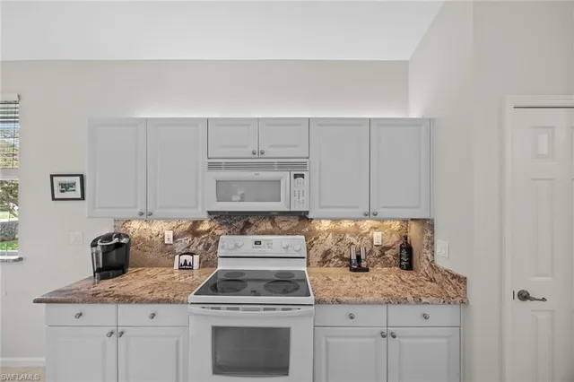 a kitchen with cabinets appliances and a counter space