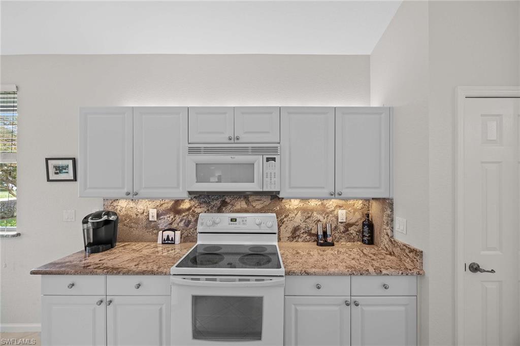 6864 Ascot Drive, Unit 5202 Naples, FL 34113 - Photo 14 of 36 a kitchen with cabinets appliances and a counter space