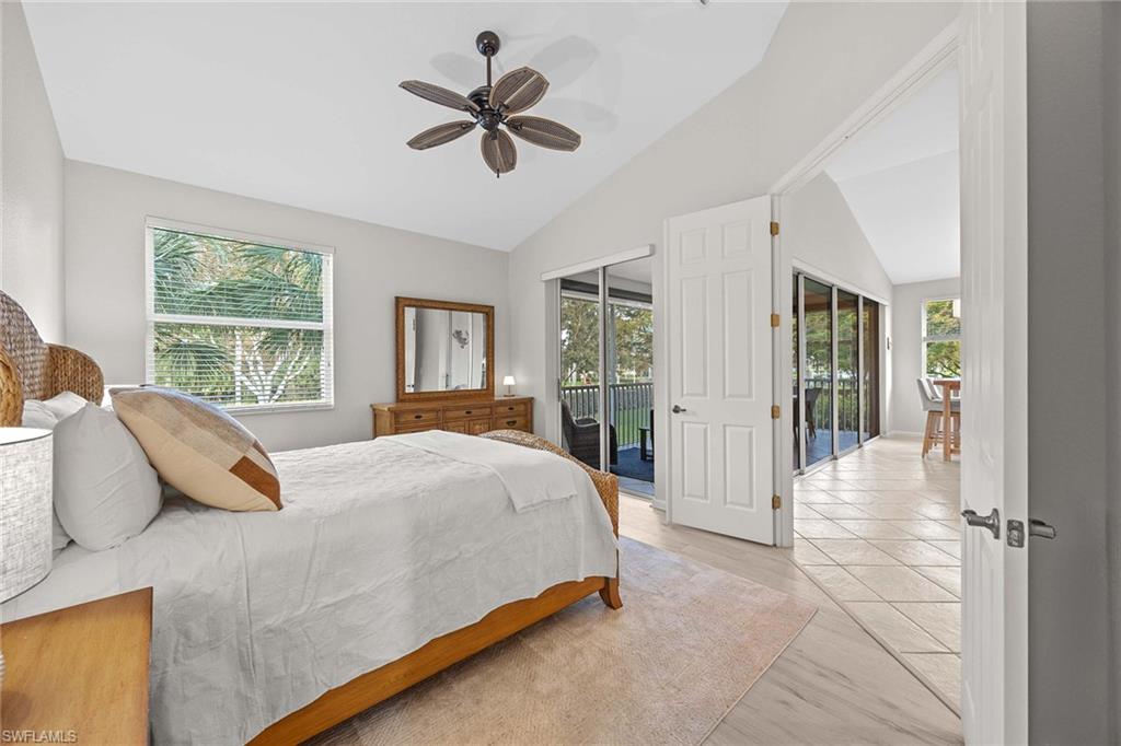 6864 Ascot Drive, Unit 5202 Naples, FL 34113 - Photo 19 of 36 a bedroom with a large bed and a chandelier