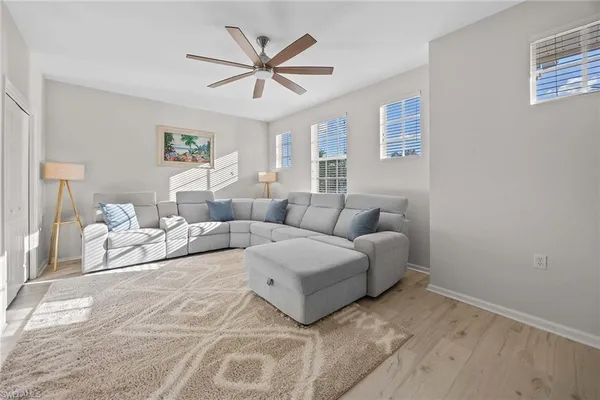 a living room with furniture and a ceiling fan