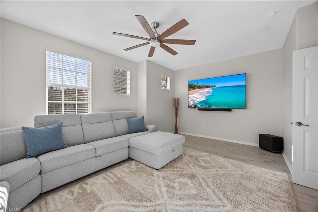 6864 Ascot Drive, Unit 5202 Naples, FL 34113 - Photo 24 of 36 a living room with furniture and a flat screen tv