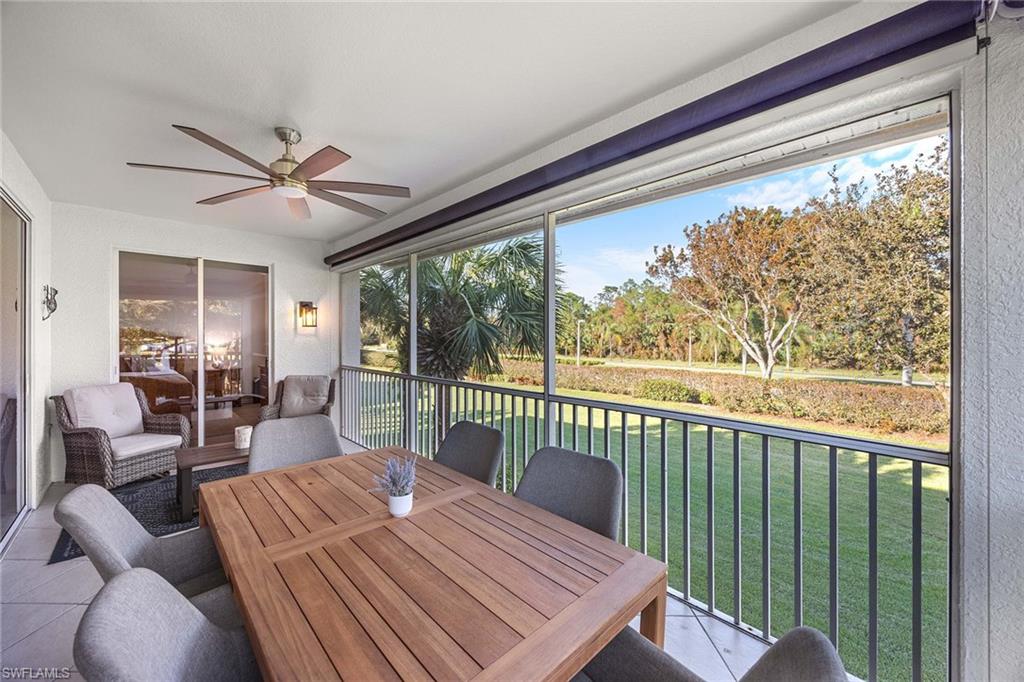 6864 Ascot Drive, Unit 5202 Naples, FL 34113 - Photo 29 of 36 a living room with furniture and a large window
