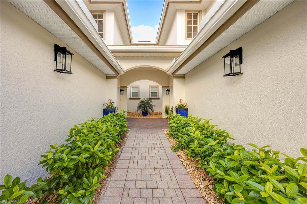6864 Ascot Drive, Unit 5202 Naples, FL 34113 - Photo 4 of 36 a view of a pathway with flower pots