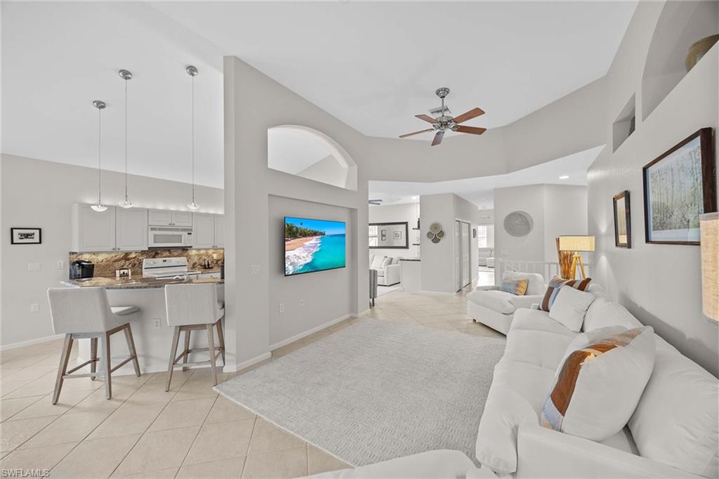 6864 Ascot Drive, Unit 5202 Naples, FL 34113 - Photo 9 of 36 a living room with furniture and a flat screen tv