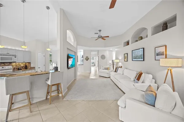 a living room with furniture and a dining table with kitchen view