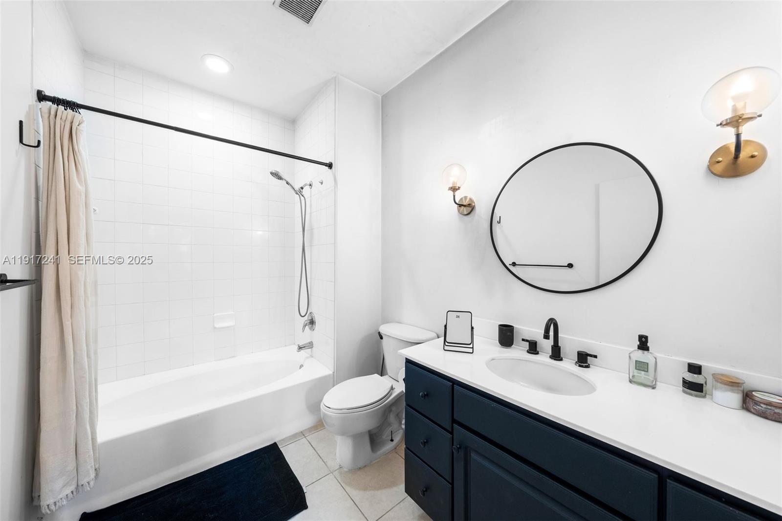 2001 Biscayne Boulevard, Unit 2409 Miami, FL 33137 - Photo 19 of 48 a bathroom with a bathtub shower sink vanity mirror and toilet