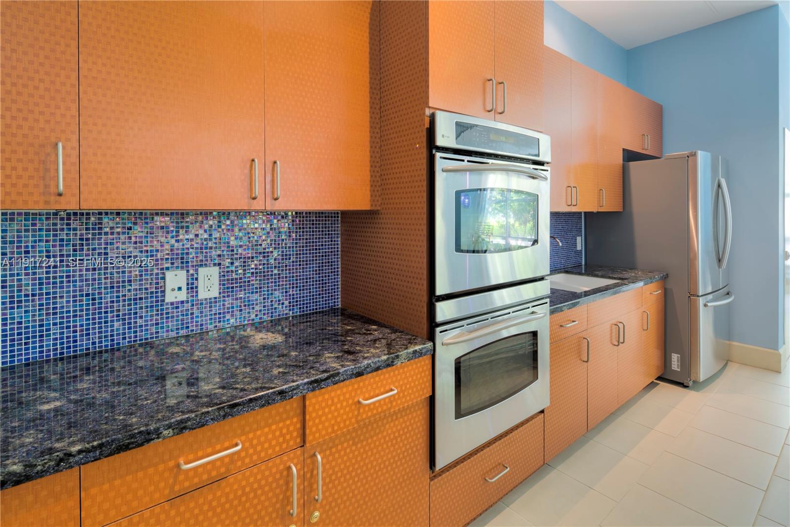 2001 Biscayne Boulevard, Unit 2409 Miami, FL 33137 - Photo 38 of 48 a kitchen with granite countertop white cabinets and stainless steel appliances