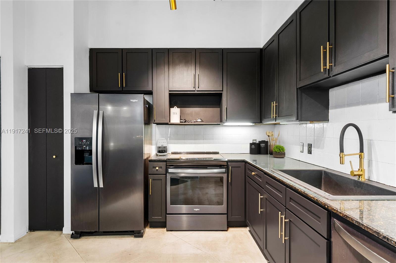 2001 Biscayne Boulevard, Unit 2409 Miami, FL 33137 - Photo 7 of 48 a kitchen with a sink a refrigerator and cabinets