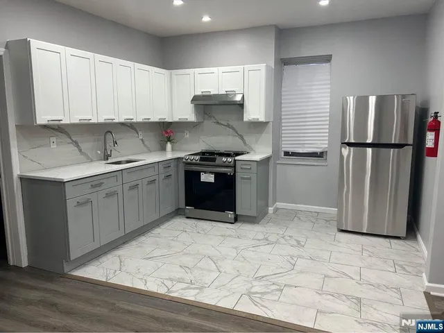 a kitchen with stainless steel appliances granite countertop a stove a refrigerator and a sink