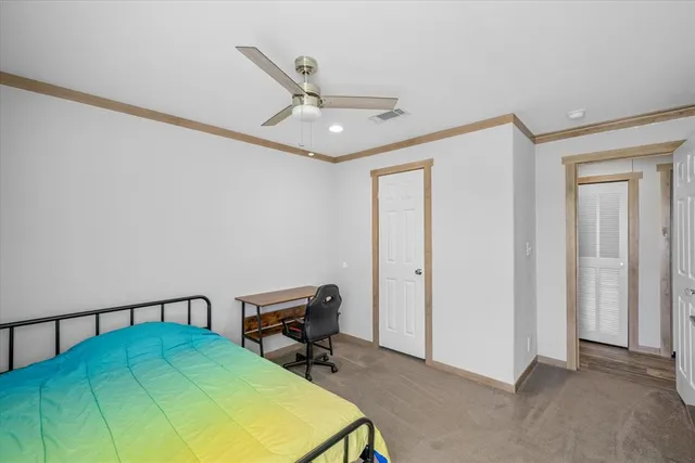 a view of a bedroom with wooden floor and bathroom
