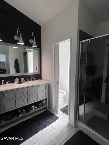 a bathroom with a sink a mirror and a shower